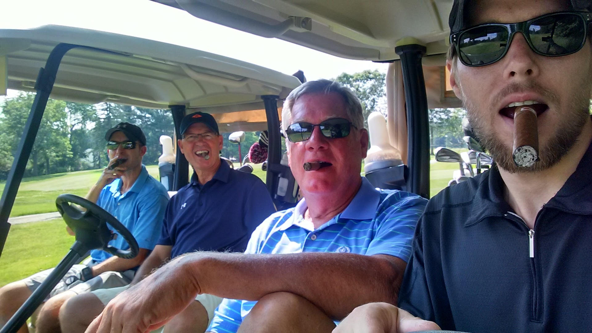 4 men in a golf cart